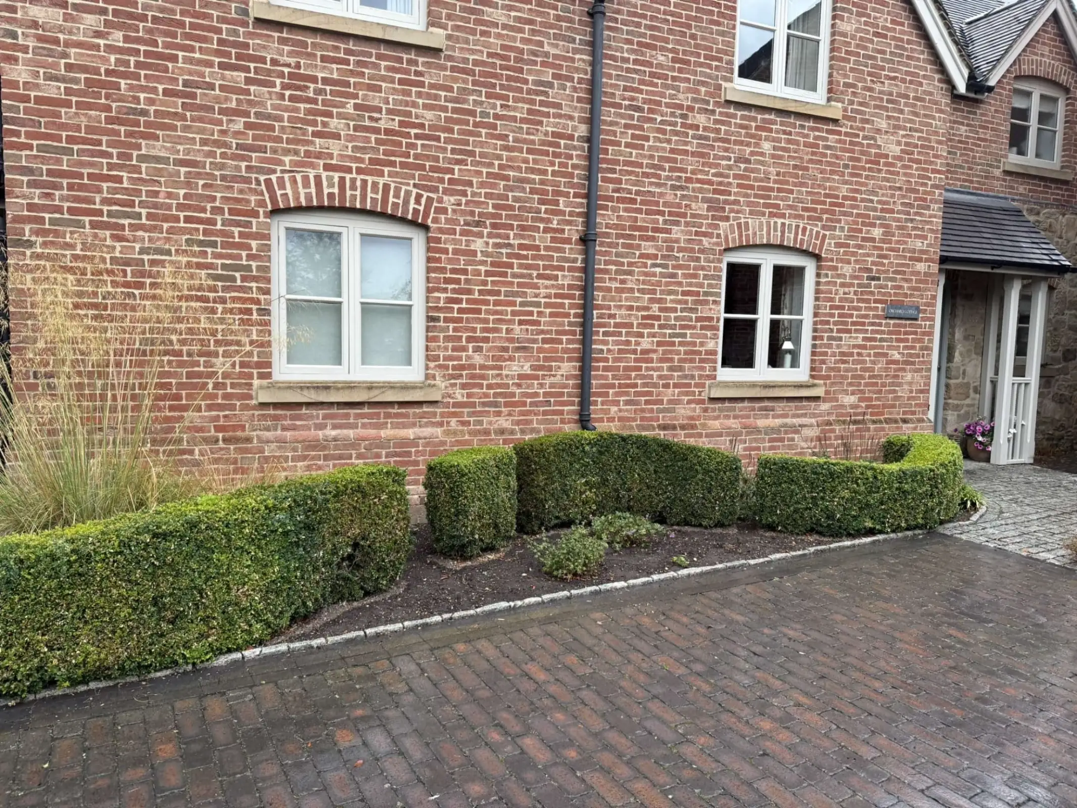 Neatly maintained garden with trimmed hedges and clean lawn