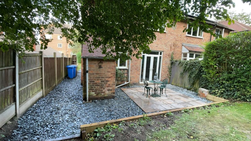 Finished compact patio with blue slate border and fence in Derby