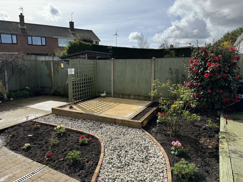 Finished garden with patio decking, stone path and borders in Derby