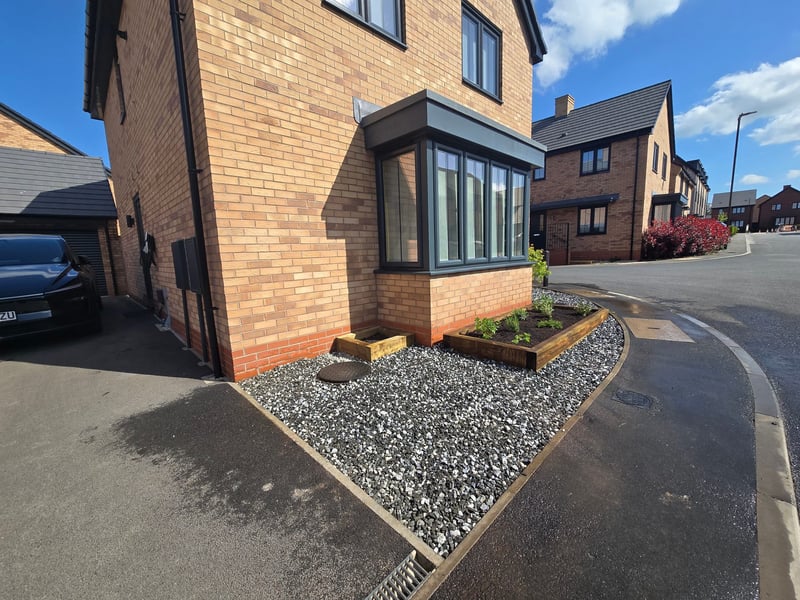 Finished landscaping project with aggregate gravel, brick borders and timber flower beds in Derbyshire